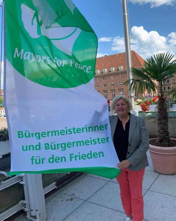 Stadtpräsidentin Bettina Aust hisst die „Mayors for Peace“-Flagge.