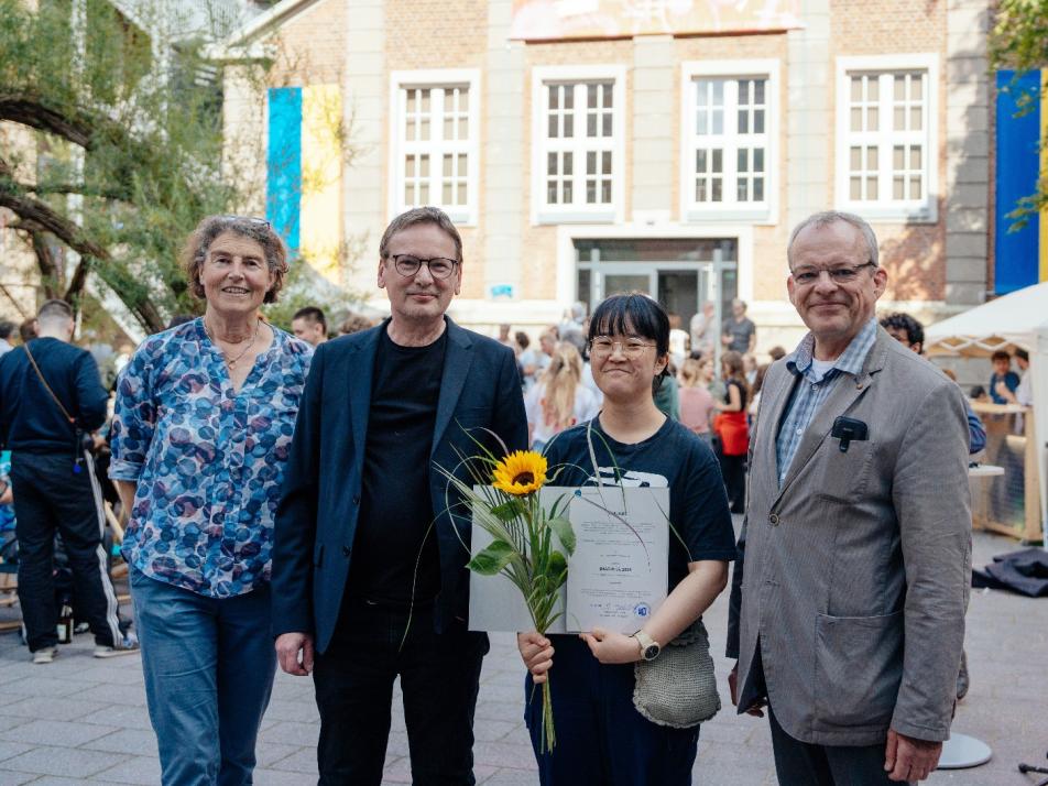 Michael Breda (r.), Vizepräsident der MuthesiusKunsthochschule, Illustrations-Professor MarkusHuber und Maud Zieschang vom International Office (l.) haben Hyeonah Kim den Preis überreicht